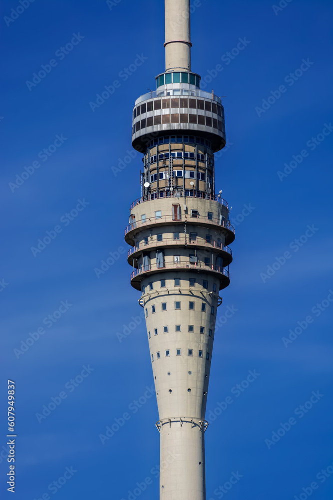 Fragment of a television tower with a television center against the blue sky near the center of Dresden in Germany.