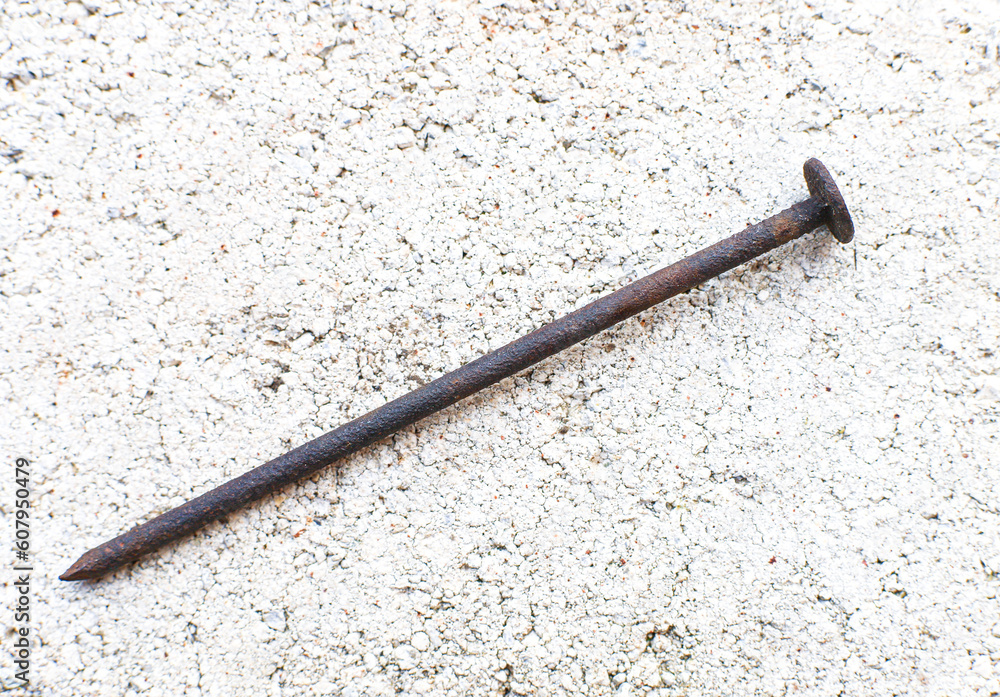 Big rusty iron nail on stone background Big rusty iron nail on stone background