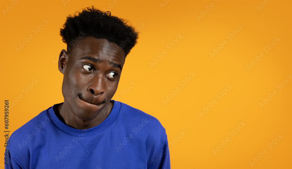 Desirous black man looking at copy space, yellow background Desirous black man looking at copy space, yellow background