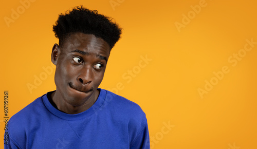 Desirous black man looking at copy space, yellow background © Prostock-studio