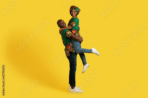 Loving black husband lifting up his pretty wife