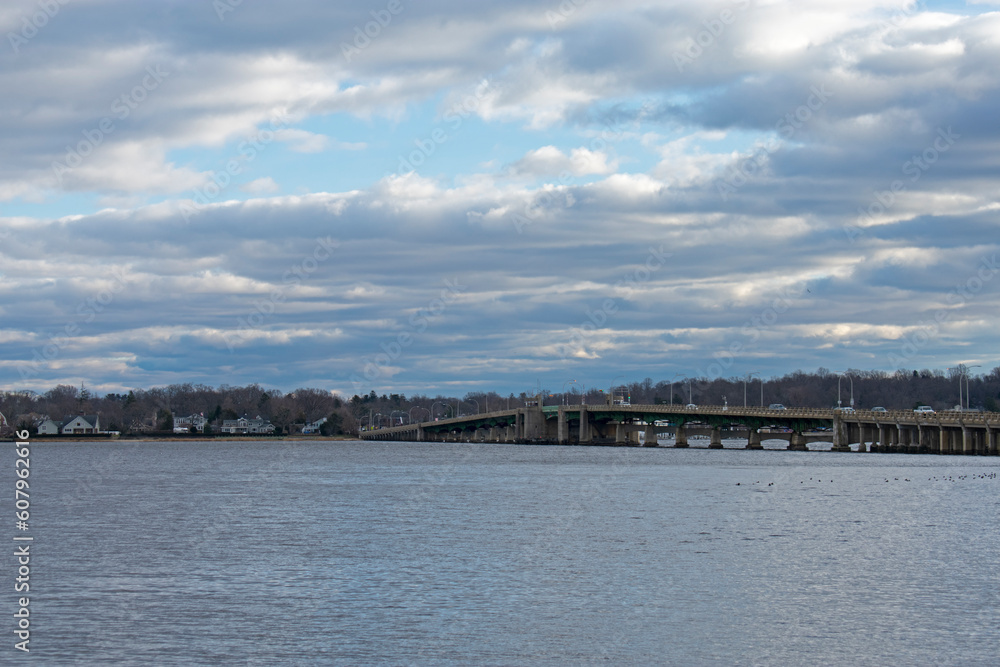View across the waters of the Navesink River at the Oceanic Bridge and the town of Rumson, New Jersey, on a cloudy day -01