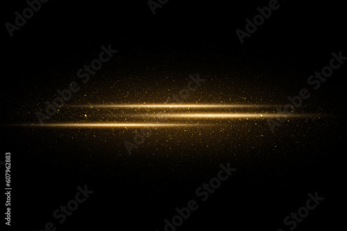 Golden sparkles and glitter on black background. Gold particles and flash of light rays on dark background photo