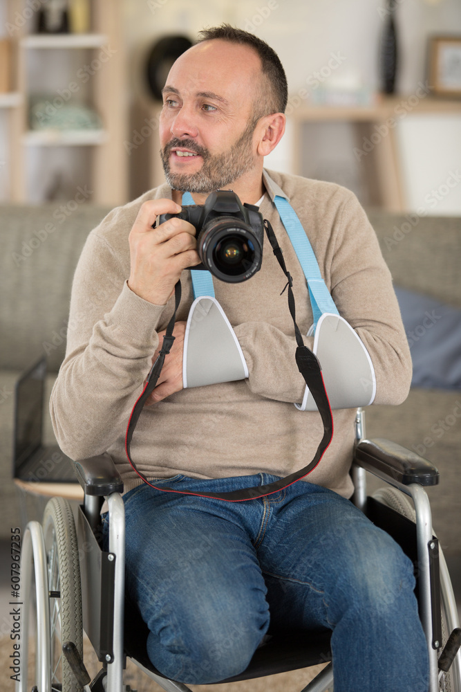 male disabled photographer holds camera in his hands