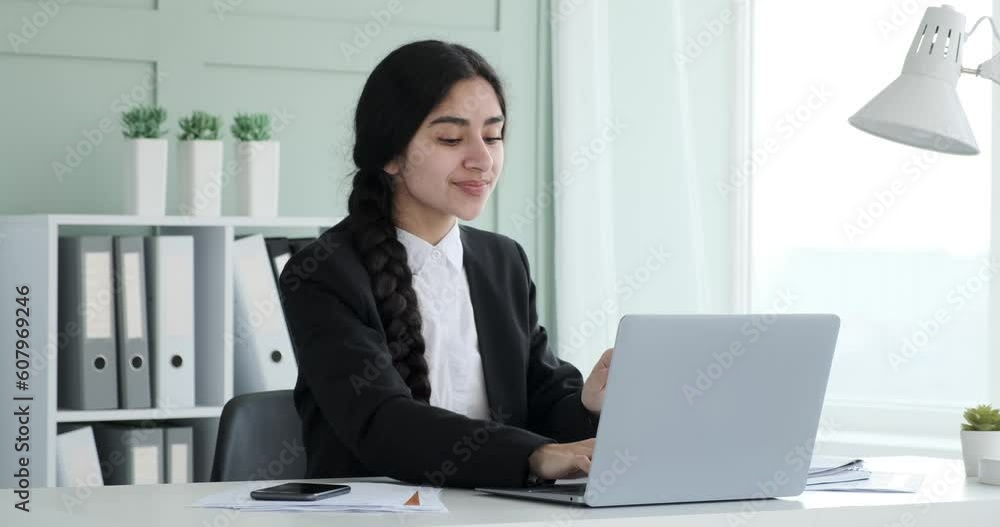 Indian businesswoman sits at office, immersed in her work. With a wide smile on her face, she singing and dancing at her workplace. She can't contain her excitement. Indian businesswoman sits at office, immersed in her work. With a wide smile on her face, she singing and dancing at her workplace. She can't contain her excitement.
