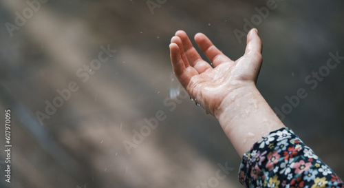 kids hands catching raindrops, weather concept. Closeup of rain falling in hands © ninelutsk
