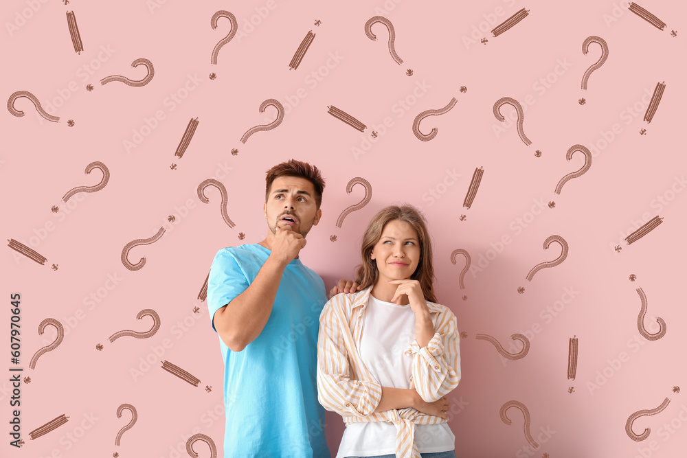 Portrait of thoughtful couple with drawn question and exclamation marks on pink background Portrait of thoughtful couple with drawn question and exclamation marks on pink background