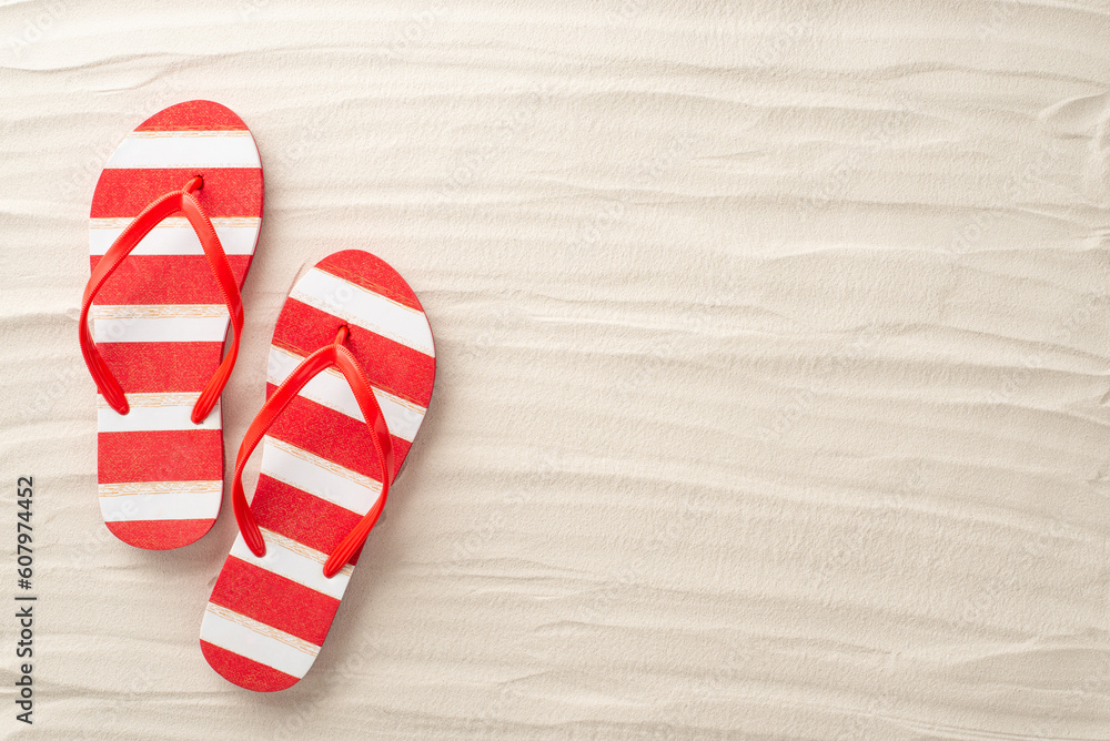 An aerial glimpse of summer bliss. Red and white striped flip-flops rest harmoniously on the sandy beach. Embrace the empty space for text or adverts An aerial glimpse of summer bliss. Red and white striped flip-flops rest harmoniously on the sandy beach. Embrace the empty space for text or adverts