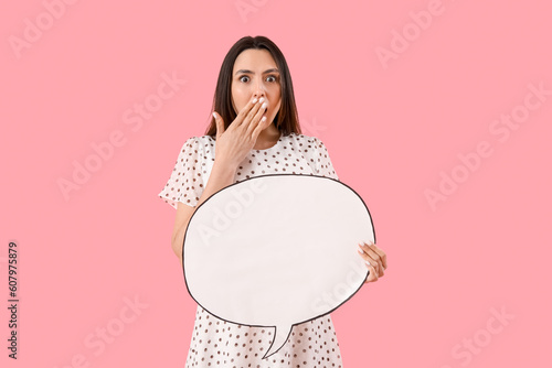 Shocked young woman with blank speech bubble on pink background