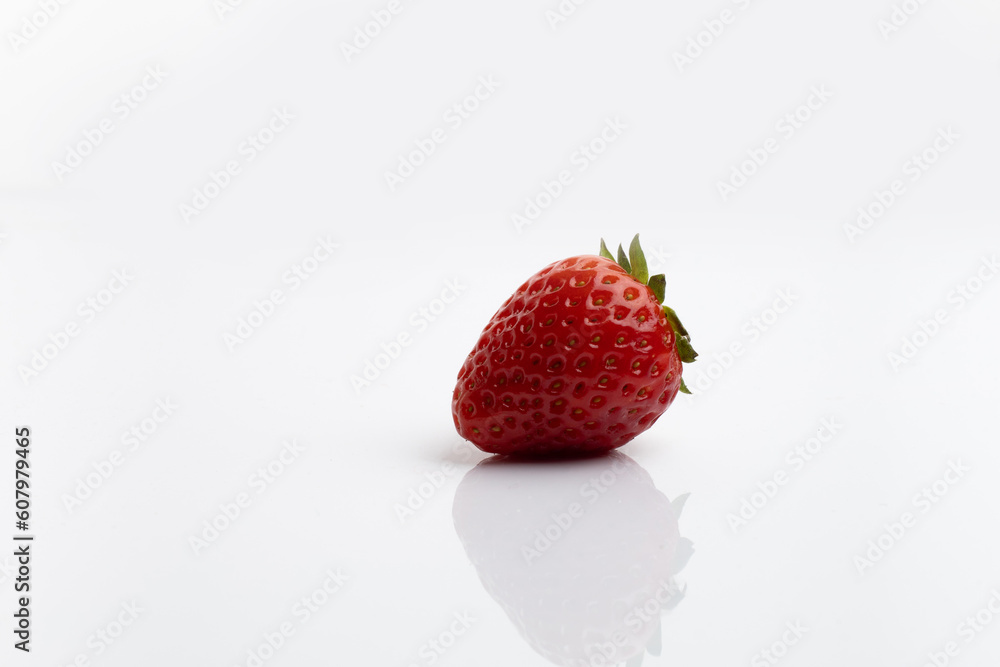 Ripe juicy strawberries with leaves on white background with reflection on the table and space for text Ripe juicy strawberries with leaves on white background with reflection on the table and space for text