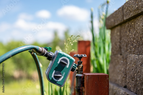 Garden water timer on a spigot with a splitter and hoses.