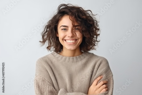 Portrait of a beautiful young woman with curly hair smiling and looking at camera isolated over white background