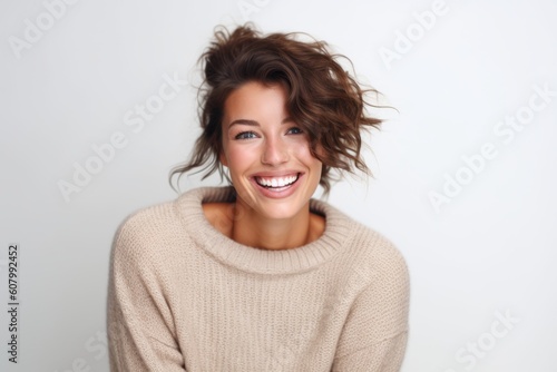 Close up portrait of a beautiful young woman laughing while standing against white background