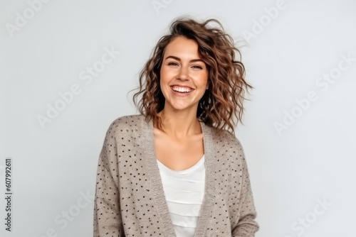 smiling young woman in sweater looking at camera isolated on grey background
