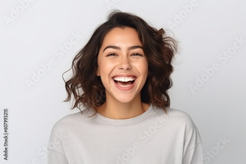 Close up portrait of a happy young woman laughing and looking at camera isolated over white background