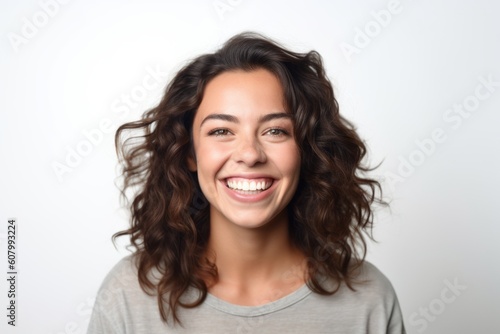 Portrait of a smiling young woman with long curly hair on a white background