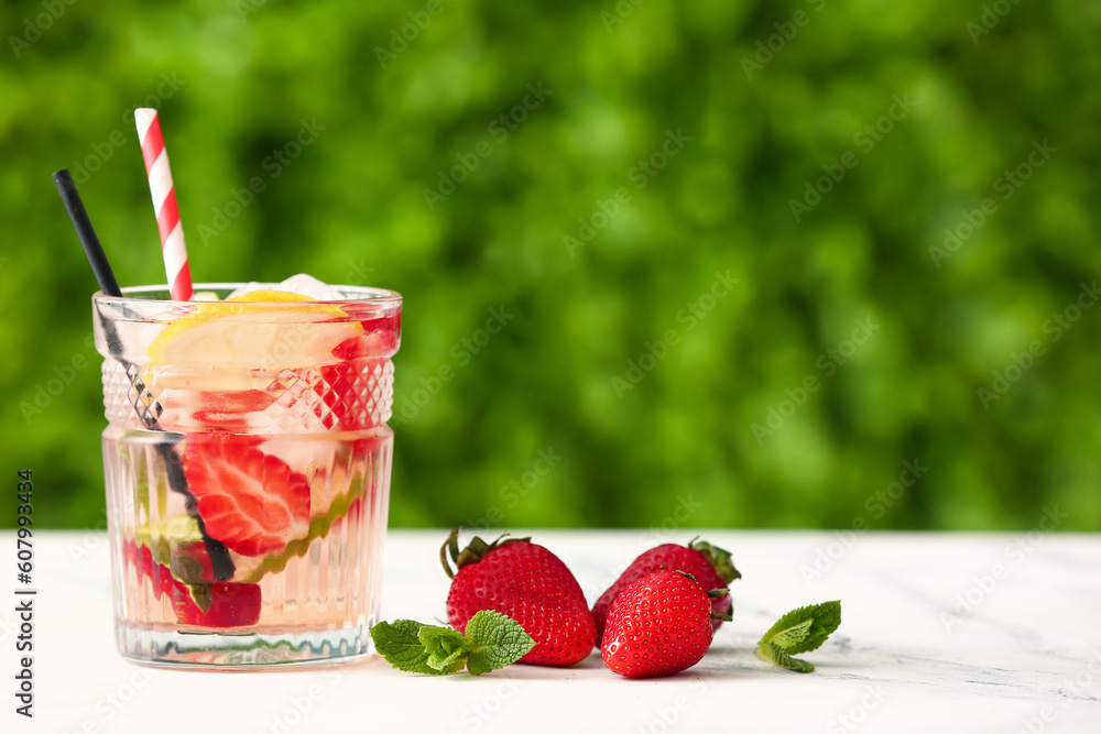 Glass of strawberry lemonade on white table outdoors Glass of strawberry lemonade on white table outdoors