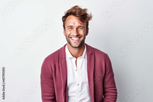 Portrait of a handsome young man smiling on a white background.