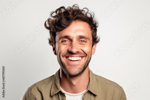 Portrait of a smiling young man with curly hair on a white background © Robert MEYNER
