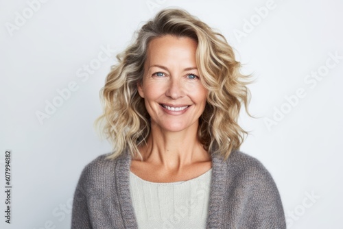 Portrait of beautiful middle aged woman smiling at camera over white background