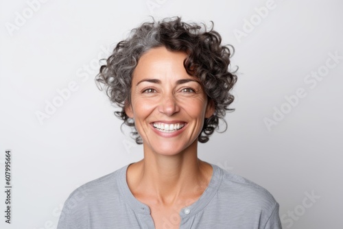 Portrait of smiling woman with curly hair looking at camera on white background