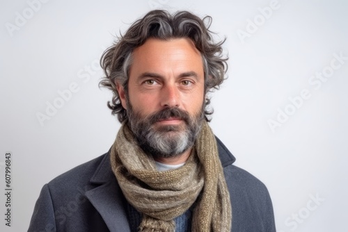 Portrait of a middle-aged man in a coat and scarf on a white background. © Robert MEYNER