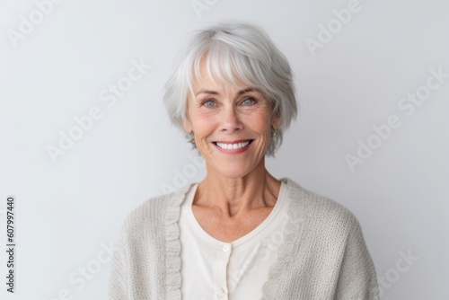 Portrait of happy senior woman looking at camera over white background.
