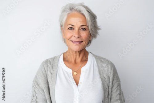 Portrait of smiling senior woman standing against white background with copy space