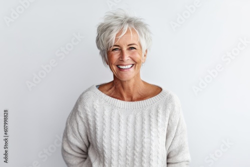 Portrait of a smiling senior woman standing against white background with copy space