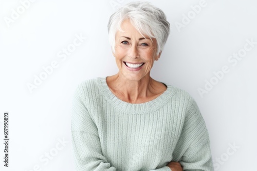 Portrait of happy senior woman standing with arms crossed against white background