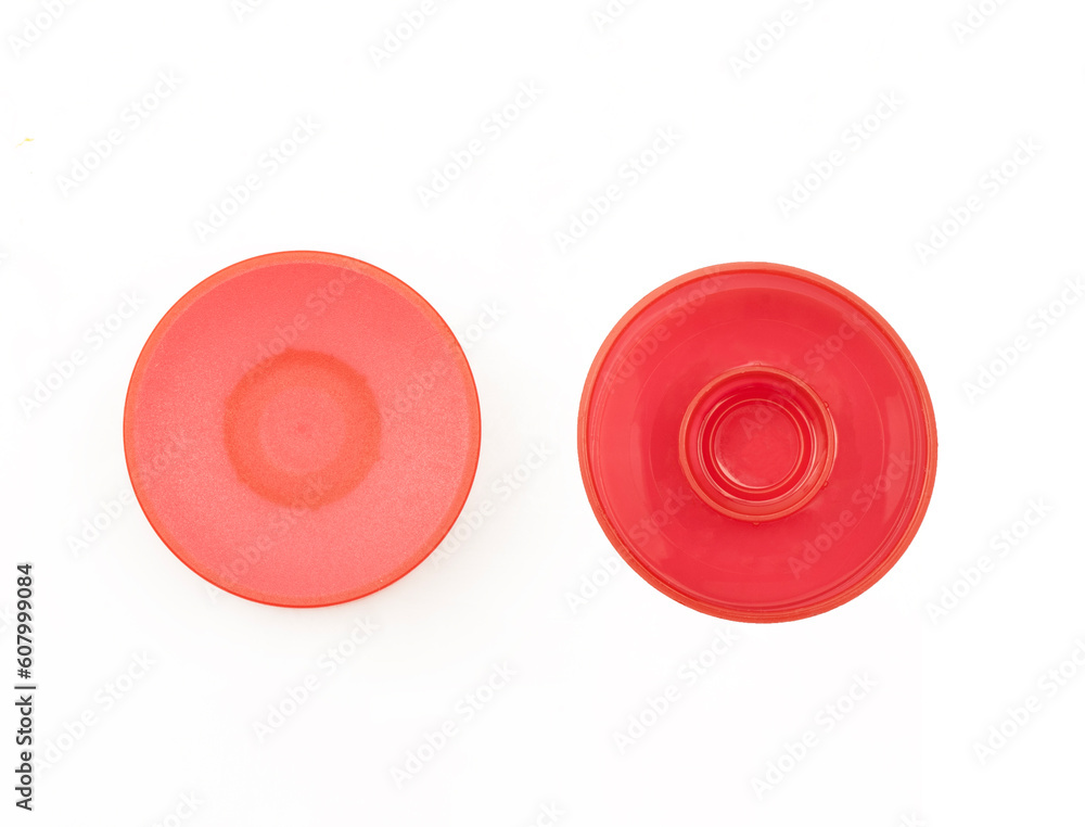 Two sides of red plastic bottle cap isolated on white background. Round cosmetics tube lid Two sides of red plastic bottle cap isolated on white background. Round cosmetics tube lid