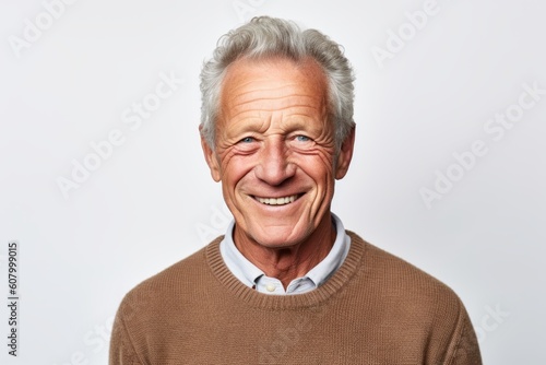 Portrait of happy senior man smiling and looking at camera on white background © Robert MEYNER
