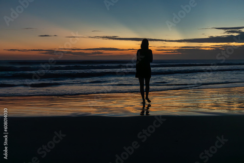 woman walking on the beach at sunset © Leonardo