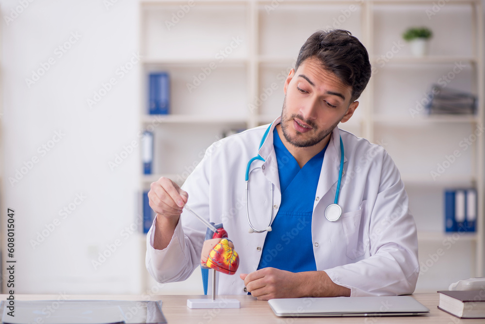 Young male doctor cardiologist sitting at the hospital Young male doctor cardiologist sitting at the hospital
