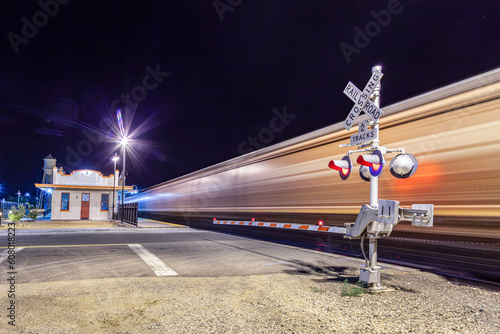 Railroad crossing by night with sign photo