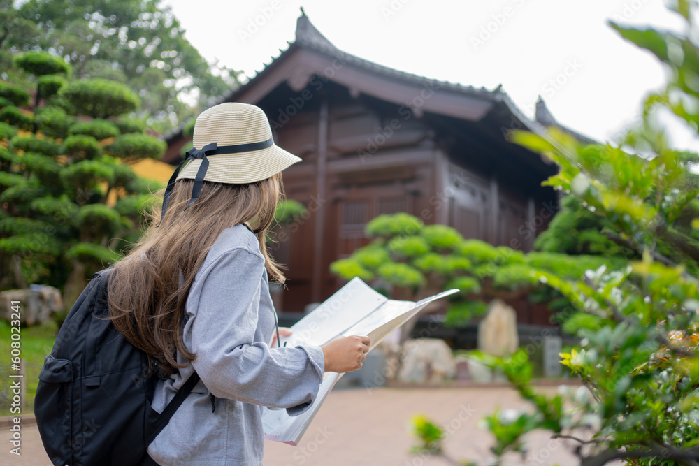 Asian tourist, cute woman with long hair are traveling in Hong Kong along with map and her camera with fun on her holiday, A temple in Hong Kong, concept travel. Asian tourist, cute woman with long hair are traveling in Hong Kong along with map and her camera with fun on her holiday, A temple in Hong Kong, concept travel.