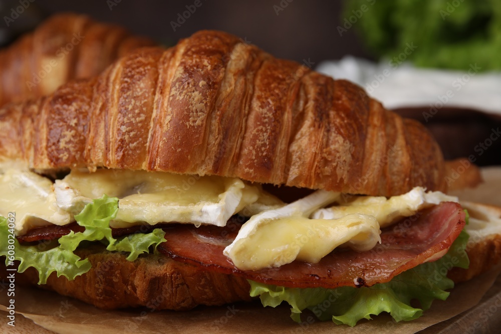 Tasty croissant with brie cheese and bacon, closeup Tasty croissant with brie cheese and bacon, closeup