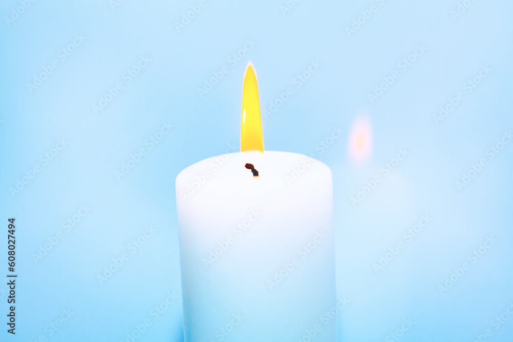 Burning candle at bright background . One white candle burning Burning candle at bright background . One white candle burning