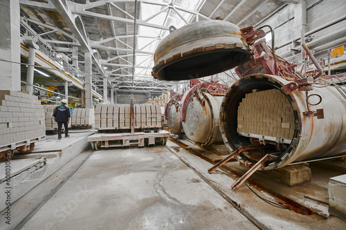 Raw bricks loaded into open autoclave for hardening in shop photo