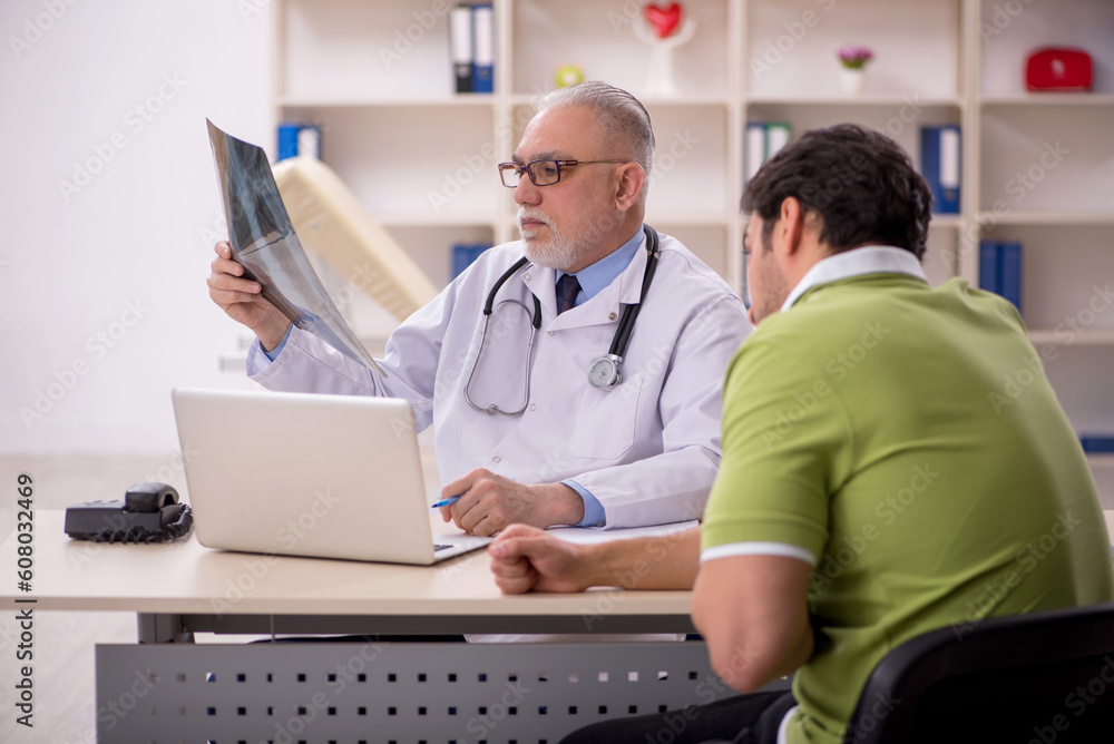 Young male patient visiting old male doctor radiologist Young male patient visiting old male doctor radiologist