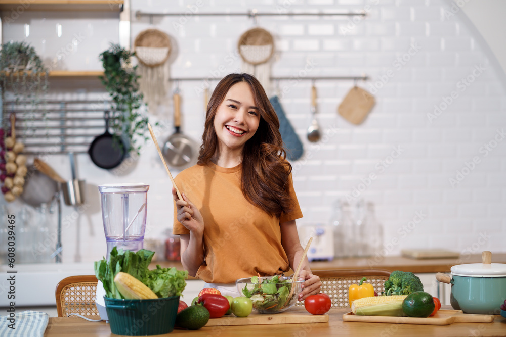 Young Asian woman is preparing a fresh healthy vegan salad with many vegetables in the kitchen, Dieting Concept. Healthy food Lifestyle. Cooking At Home. Young Asian woman is preparing a fresh healthy vegan salad with many vegetables in the kitchen, Dieting Concept. Healthy food Lifestyle. Cooking At Home.