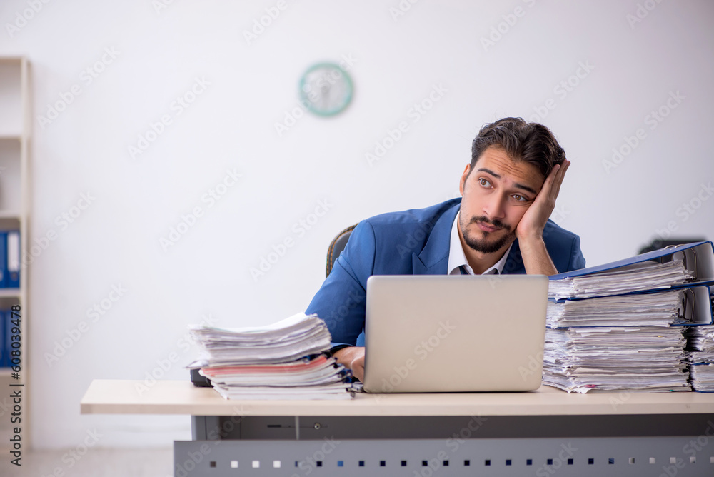 Young male employee and too much work in the office