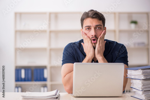 Young male employee sitting at workplace