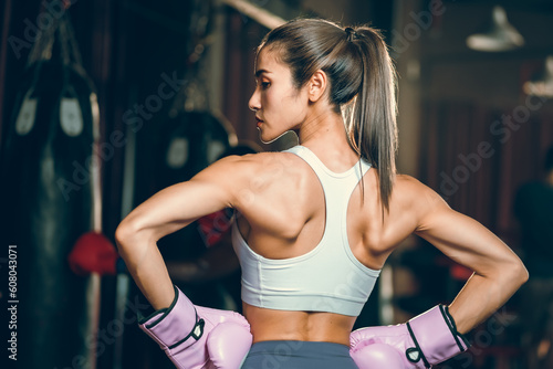 sporty athlete young Asian woman wearing sportswear and pink punching gloves practicing boxing martial arts. fit attractive female doing boxing at the fitness kickboxing gym  Portrait of female boxer