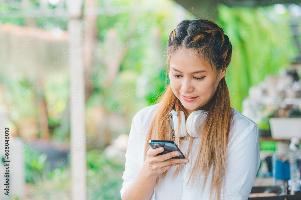 Smiling young asian woman using mobile phone checking social media,app playing game, shopping online, ordering delivery relax Smiling young asian woman using mobile phone checking social media,app playing game, shopping online, ordering delivery relax