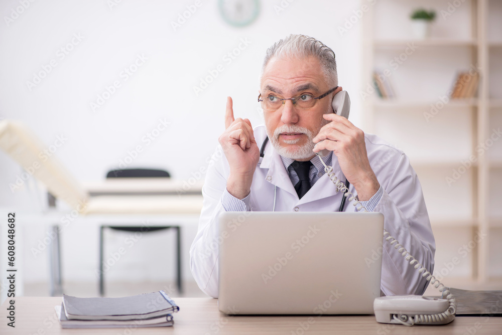 Old male doctor in telemedicine concept Old male doctor in telemedicine concept