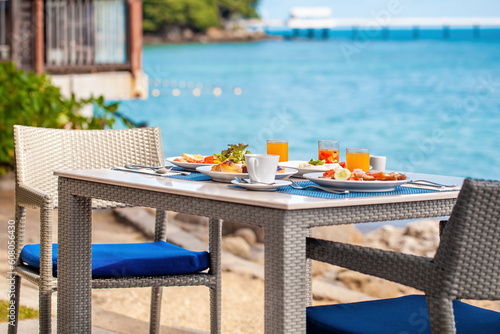 Φωτογραφία Breakfast table full of food at seaside restaurant, with sea view and waves