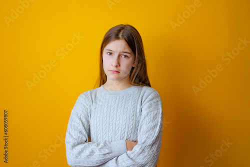 Serious little girl with cross arms on chest and look determined