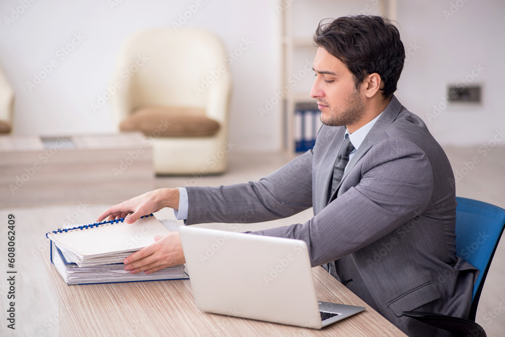 Young male employee working in the office Young male employee working in the office