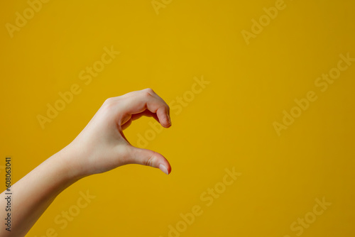 Young adult woman forming shape of half of heart with her fingers